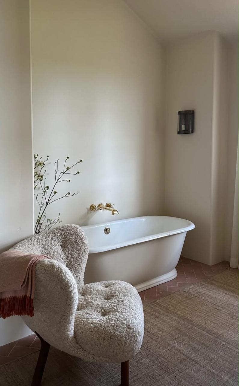 Baño residencial con tina y acabados cálidos